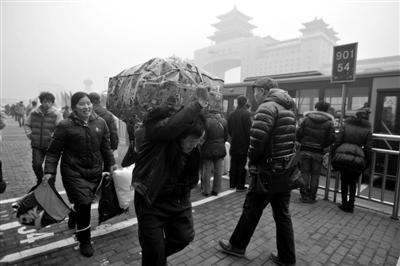 昨天下午，北京西站北侧，一名回家的旅客扛着行李前往北京西站。实习生 杨奉焓 摄